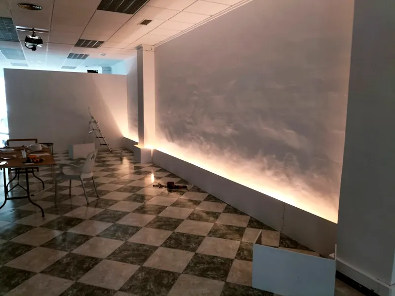 Pared de paneles blancos con iluminación indirecta montada para una exposición